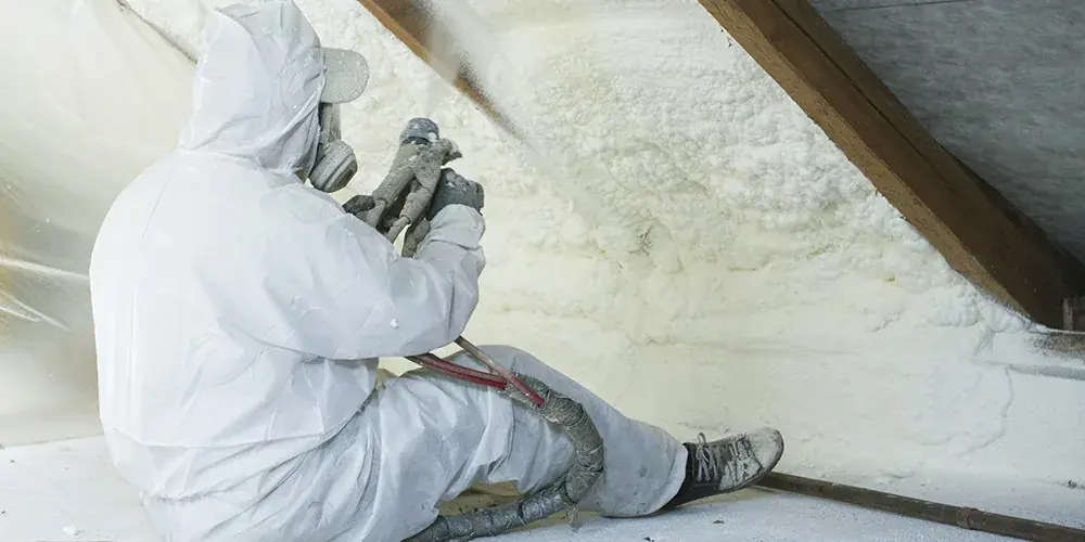 Pågående installation av RadonFoam i tak, takstolar synliga
